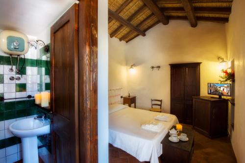 a bathroom with a bed and a sink in a room at Antico Borgo in Galtellì