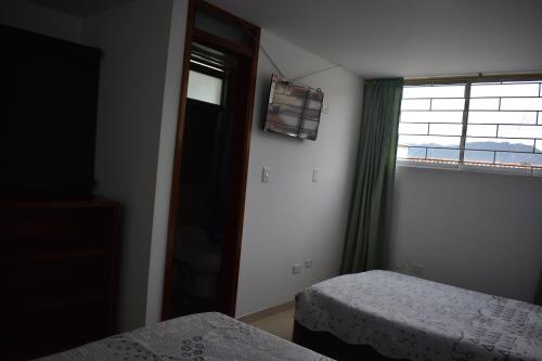 a hotel room with two beds and a window at La Puerta Rota in Zipaquirá