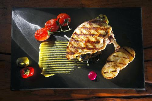 a black plate with meat and vegetables on a table at Conte Marino Villas in Maleme