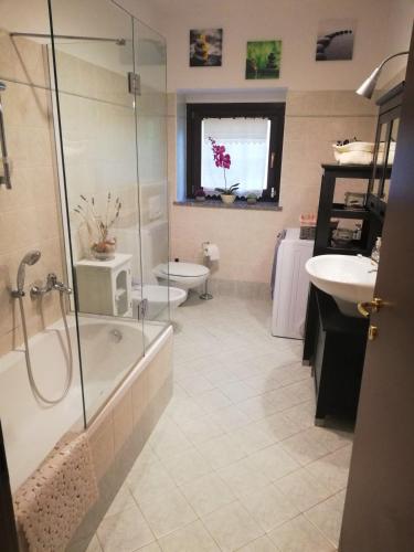 a bathroom with a shower and a tub and a sink at Luino - Scintilla di Lago in Luino