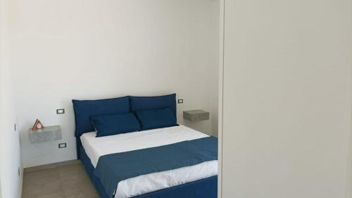 a bedroom with a bed with blue and white at Villetta vicino al mare in Porto Palo