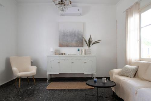 a white living room with a couch and a table at Kilada Country House in Kilada