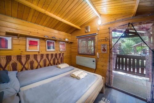 um quarto com uma cama numa casa de madeira em Páros faház em Balatonföldvár