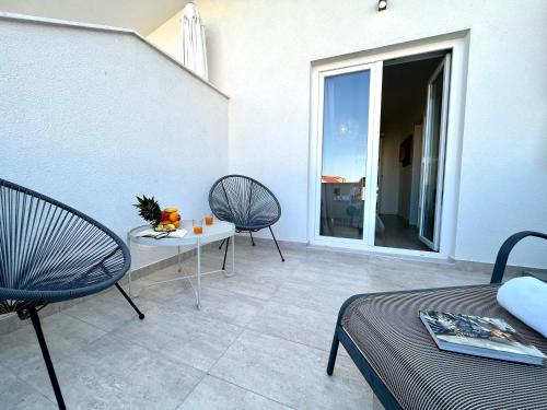 a patio with two chairs and a table and a window at Apartments and Rooms Mateša in Vodice
