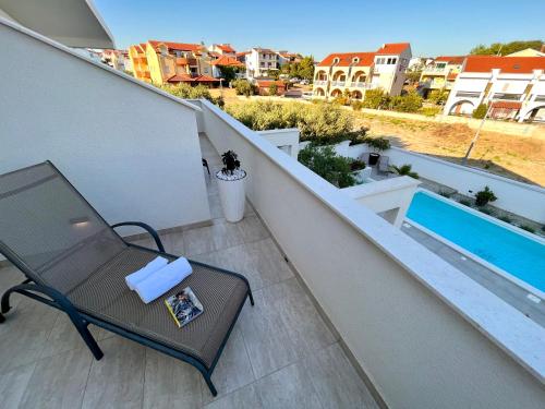 a balcony with a table and a swimming pool at Apartments and Rooms Mateša in Vodice