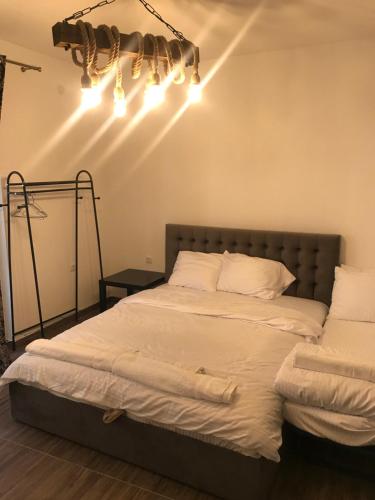 a bedroom with a bed with white sheets and lights at Apartmani Anja Ohrid in Ohrid