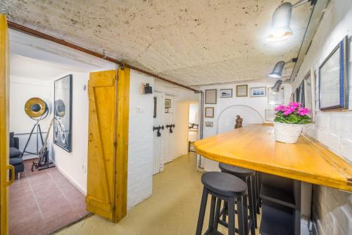 a kitchen with a wooden counter and stools at Ádám Apartman in Balatonföldvár