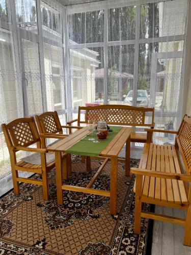 a dining room with a table and chairs and windows at Raduga West_Issyk Kul, Kyrgyzstan in Koshkolʼ