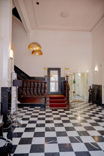 a lobby with a checkered floor and a staircase at The Velvet Lodge in The Hague