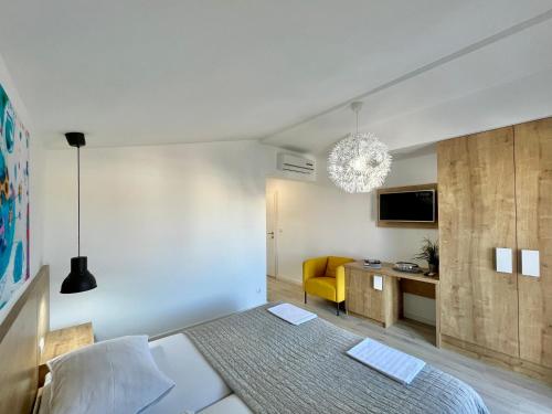 a bedroom with a bed and a desk and a television at Apartments and Rooms Mateša in Vodice