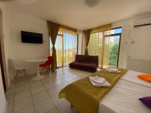 a bedroom with two beds and a living room with a table at Garsoniere Victor Seaview Aer Conditionat- Bucatarie-Primim Carduri Vacanta-Pet Friendly la 3 minute de Plaja Reyna-Zoom Beach in Constanţa
