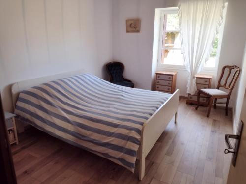 a bedroom with a bed and a window and chairs at La Maison des Roses 1-Bed House in Genouille in Génouillé