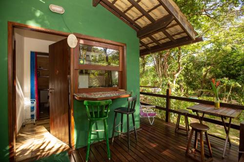 une maison verte avec un bar sur une terrasse dans l'établissement Recanto dos Passaros, à Praia do Forte