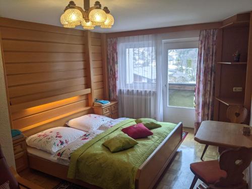 sypialnia z łóżkiem z drewnianym zagłówkiem i oknem w obiekcie Montahaus w mieście Vandans