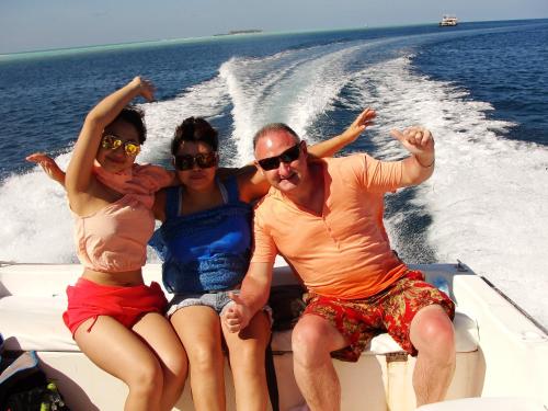 three people sitting on a boat in the water at Ras Rana Lodge in Rasdu