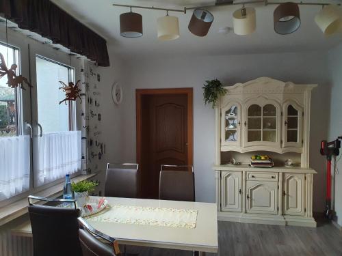 梅德巴赫的住宿－Fewo TaLuLa - Sauerland mit Hund，一间配备有桌子和白色橱柜的用餐室