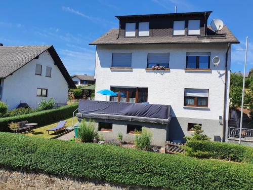 梅德巴赫的住宿－Fewo TaLuLa - Sauerland mit Hund，一座白色的大房子,上面有蓝色的油布