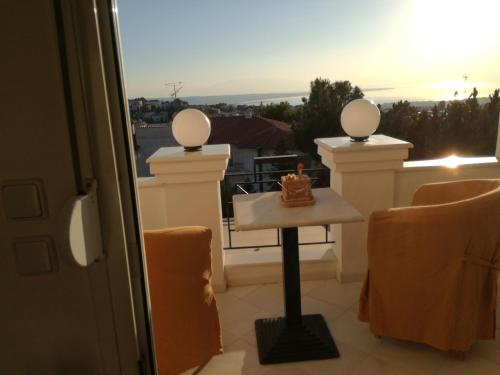 a balcony with a table with a cake on it at Πολυτελής κατοικία με θέα τον Θερμαϊκό in Thessaloniki