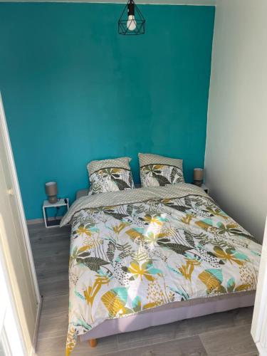 1 dormitorio con 1 cama con pared azul en Logement en bord de port, en Soubise