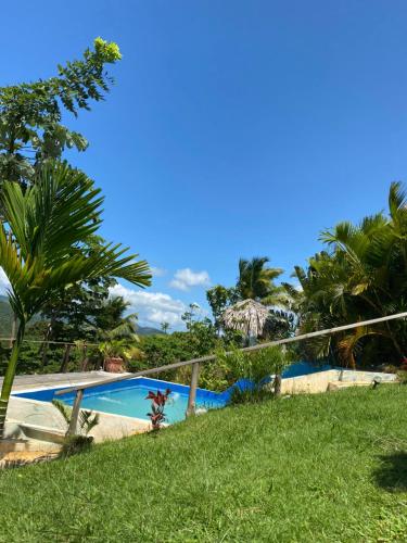 a swimming pool in a yard with palm trees at Tropical Cottage En Eco Casa Algana in El Limón