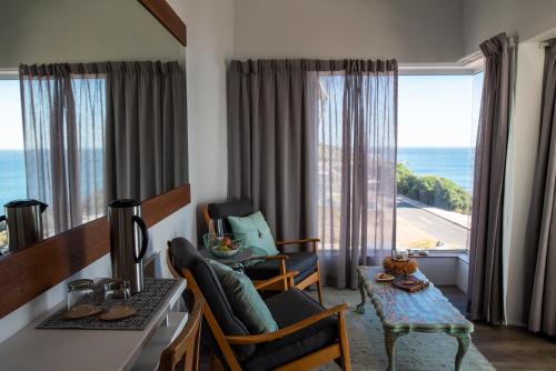 a living room with a view of the ocean at Whalesong Lodge in Gansbaai