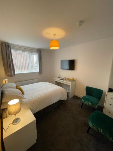 a bedroom with a bed and a green chair at The seahorse in Blythe