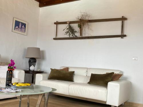 a living room with a white couch and a table at Casa Camelio in Mácher
