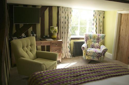 a bedroom with a bed and a chair and a desk at The Oaksmere in Eye