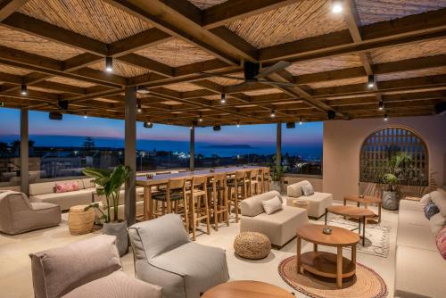 a lobby with chairs and tables and a bar at Paralos Venus Suites Adults Only in Hersonissos