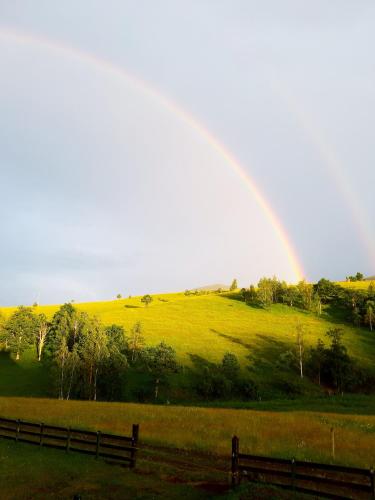 a rainbow over a green field with a fence at Casa Mila Zlatibor in Zlatibor