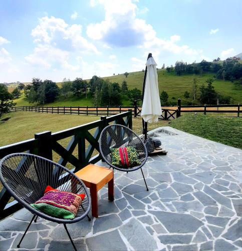 a patio with two chairs and an umbrella at Casa Mila Zlatibor in Zlatibor