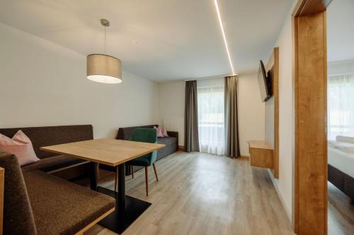 a living room with a table and a couch at Stangl Appartements in Flachau