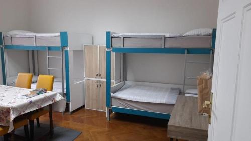 two bunk beds in a room with a table and chairs at Zeynep Apartments in Sarajevo