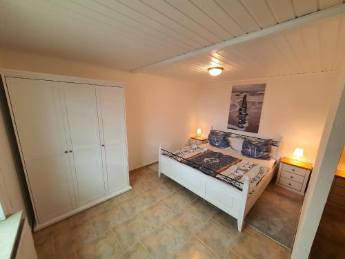 a bedroom with a bed and a white cabinet at Lindi in Ostseebad Koserow