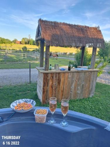 - une table avec deux verres de vin et un kiosque dans l'établissement Soirée romantique avec Bain Nordique sur Domaine Equestre, Studio Tout Confort, à Chapelle-Voland