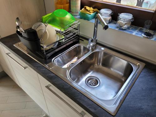 a kitchen sink with a dish drying rack next to it at Villa La Pelosa Stintino in Stintino