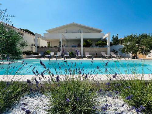 a swimming pool in front of a house at Apartments and Rooms Mateša in Vodice