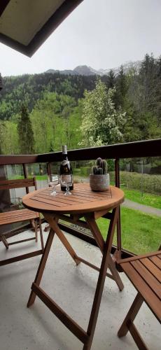 - une table de pique-nique en bois avec une bouteille de vin dans l'établissement Un havre de paix aux pieds des chemins de montagne, aux Contamines-Montjoie