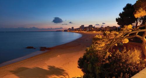 a view of a beach with a city in the background at Hotel Costa Brava in Platja  d'Aro