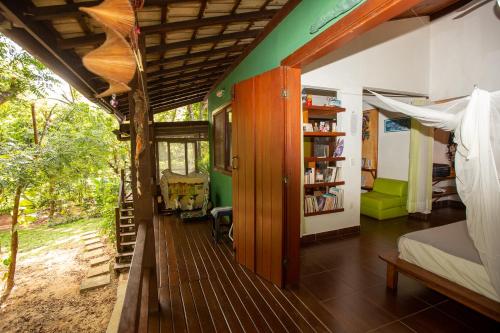 a room with a bed and a book shelf at Recanto dos Passaros in Praia do Forte