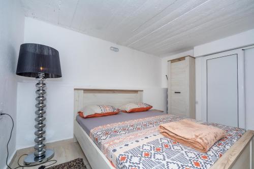 a bedroom with a bed and a lamp in a room at Apartman Sara in Bar
