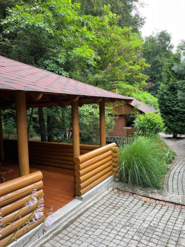 a wooden deck with a gazebo in a garden at Fantasia Hotel in Polyana