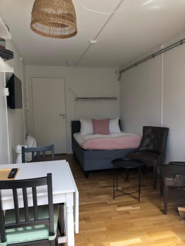a room with a bed and a table and chairs at Kaggeholms strandboende in Ekerö