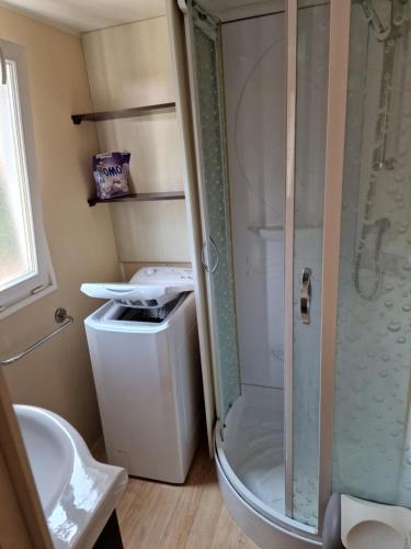 ein Bad mit einer Dusche, einem WC und einem Waschbecken in der Unterkunft Grand Mobile home dans camping in Mimizan