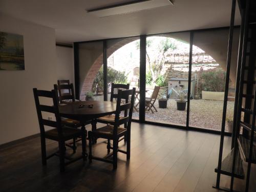 d'une salle à manger avec une table, des chaises et une fenêtre. dans l'établissement El pati català, à Fourques