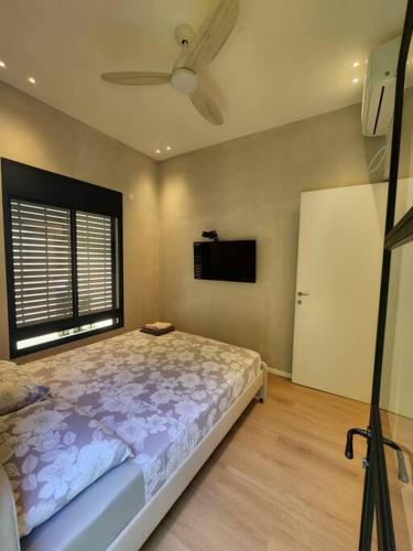a bedroom with a bed and a ceiling fan at cohen's house in Haifa