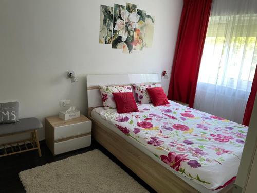 a bedroom with a bed with a floral comforter at A3M APARTMENT in Deva