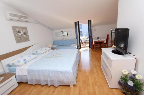 a bedroom with a bed and a flat screen tv at Apartments Dujmović in Rovinj