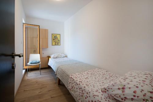 Un dormitorio con dos camas y una silla. en Stone House Marin, en Kostanje