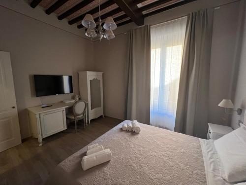 a bedroom with a bed with a television and a table at La Perla del Borgo B&B in Pisa